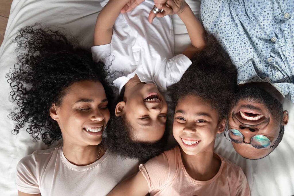 Family Laughing on a Hotel Bed